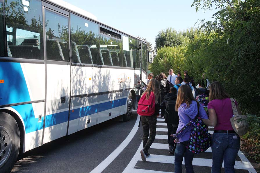 Collégiens rentrant dans un bus scolaire